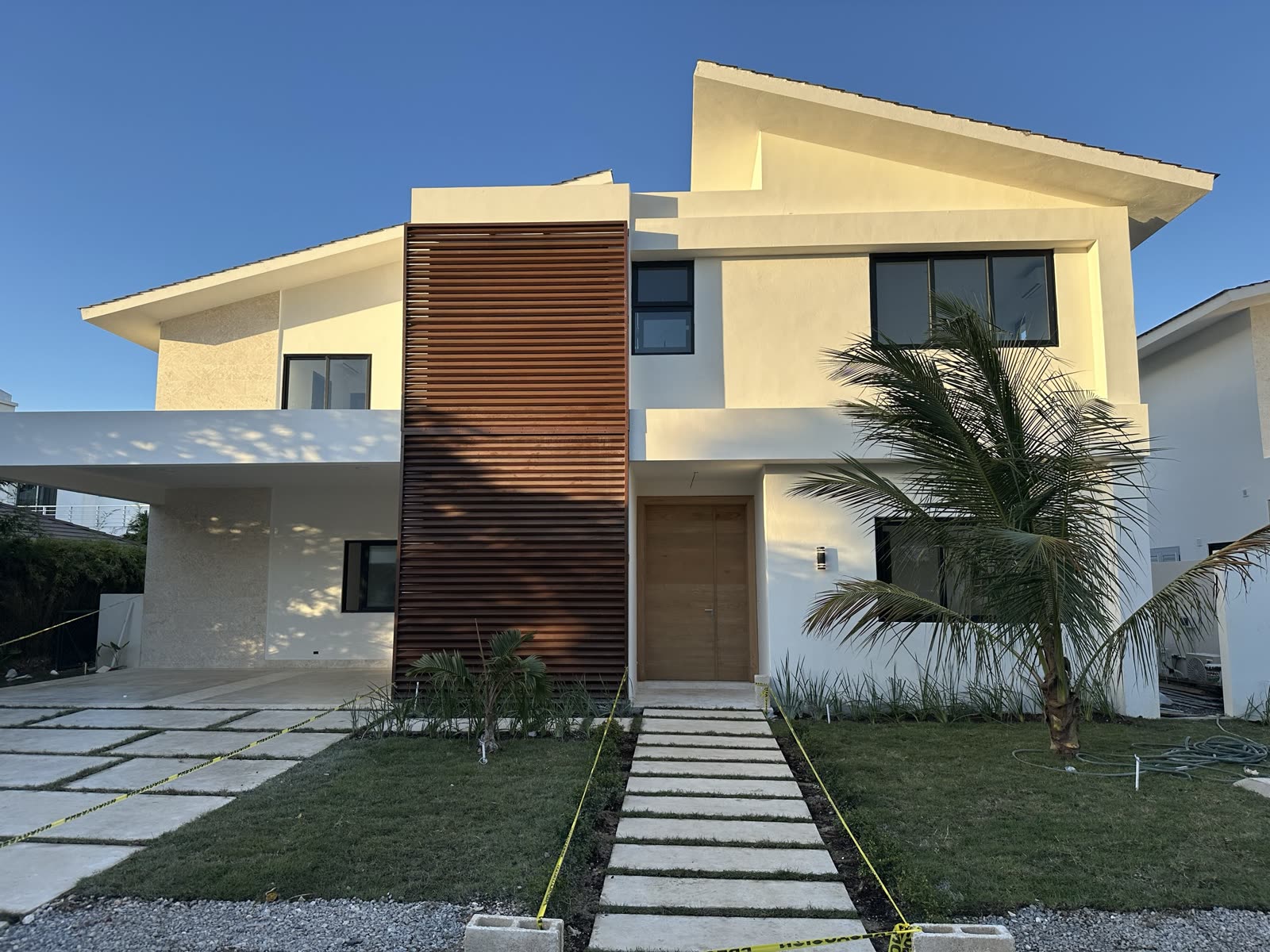 Villa moderne blanche à Punta Cana, allée dallée et palmiers